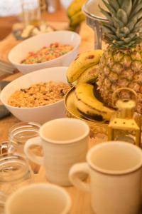 une table avec des tasses et des bols de céréales et de fruits dans l'établissement Niddo Suesca, à Suesca