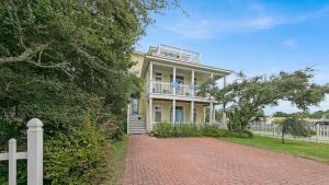 a house with a white fence and a brick driveway at Seashine and Sunkises - Great pricing near Seaside in Santa Rosa Beach