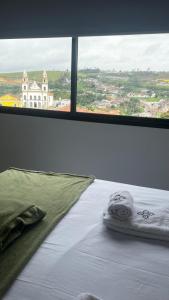 a bed in a room with a large window at Zuppolini Garden Hotel Oficial in Bananeiras