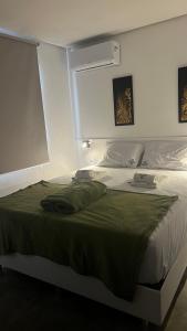 a bedroom with a large bed with a green blanket at Zuppolini Garden Hotel Oficial in Bananeiras