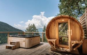 un baño en una bañera de hidromasaje en la terraza de una casa en un árbol en Studio Cocon aux Orres 1650 au pied des pistes et vue montagne, en Les Orres