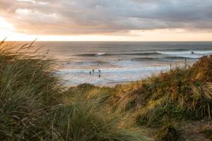 a group of people on a beach with waves at Newquay Horizons in Newquay
