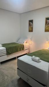 two beds in a room with two bedsitures at Zuppolini Garden Hotel Oficial in Bananeiras