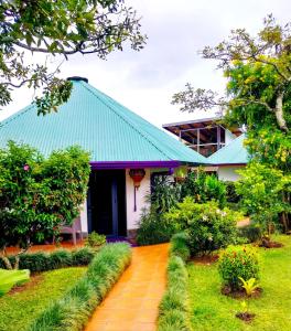 uma casa com um telhado azul e um jardim em Hotel Isla Verde em Boquete