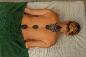 a woman with a butterfly on her back laying on a bed at Leyenda Boutique Hotel & Spa in Sámara