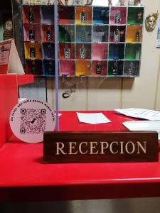 una mesa roja con un cartel que diga recepción en Hostal Palafox, en Barbastro