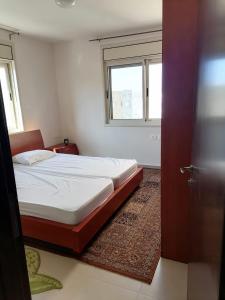 niewielka sypialnia z łóżkiem i oknem w obiekcie Rawabi appartment w mieście ‘Ajjūl