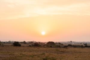 a sunset in the desert with the sun setting at Masseria Gorgognolo in Ostuni