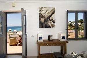 a living room with two speakers on a table and a balcony at Casa Sereia Praia in Salema