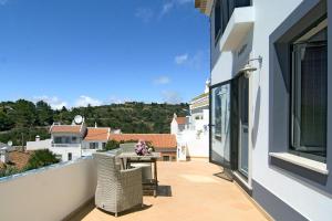 - un balcon avec une table et des chaises dans un bâtiment dans l'établissement Casa Sereia Praia, à Salema