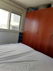 sypialnia z łóżkiem i drewnianą szafką w obiekcie Rawabi appartment w mieście ‘Ajjūl