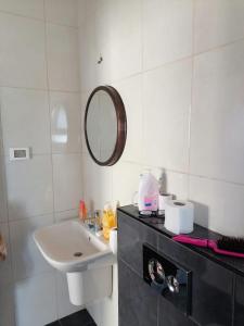W białej łazience znajduje się umywalka i lustro. w obiekcie Rawabi appartment w mieście ‘Ajjūl