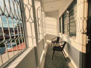 a balcony with two chairs and a view of the ocean at A Humble Abode Homestay By irainbow in Ipoh