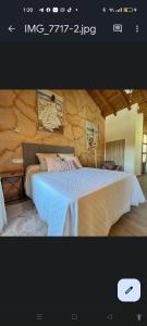 ein Schlafzimmer mit einem großen Bett und einer Steinmauer in der Unterkunft APARTAMENTOS TURISTICOS LAS CANDELAS in Puebla de Sanabria