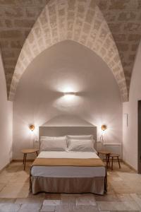 a bedroom with a large bed in an archway at Masseria Gorgognolo in Ostuni +37 photos