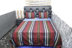 ein Bett mit einer bunten Decke und Kissen darauf in der Unterkunft Villa Flo Residence in Lomé