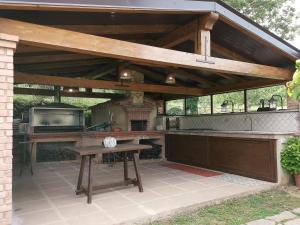 una cocina al aire libre con mesa y parrilla en Residence La Cessuta-CILENTO, en San Giovanni a Piro
