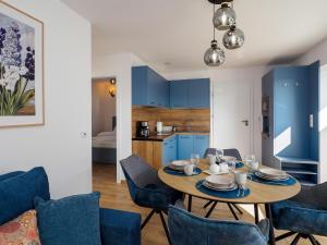 a dining room with a table and blue chairs at Ostoja Colette in Jarosławiec