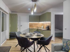 a kitchen and dining room with a table and chairs at Ostoja Colette in Jarosławiec