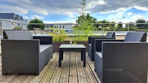a patio with wicker chairs and a table on a deck at Le Canyon Rouen Centre by MyFrenchPAT Terrasse & Parking in Rouen