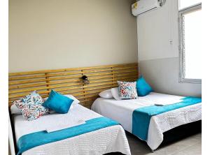 dwa łóżka siedzące obok siebie w pokoju w obiekcie Apartamento Familiar Buga - Basílica señor de los milagros w mieście Buga