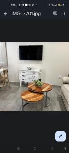 a living room with a table and a flat screen tv at APARTAMENTOS TURISTICOS LAS CANDELAS in Puebla de Sanabria