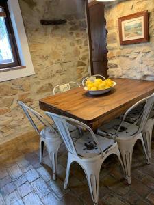 una mesa de madera con sillas y un bol de fruta. en Casas de Almajar, en Prado del Rey