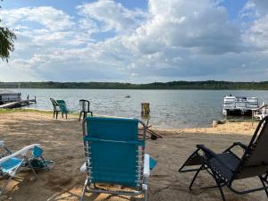 a group of chairs sitting on the shore of a lake at Paradise Cottage C2 in Greenville