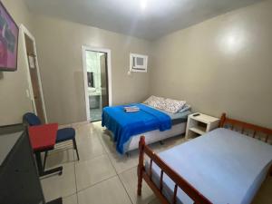 1 dormitorio con 1 cama, 1 mesa y 1 silla en Lurviz Home Suítes, en Cabo Frío