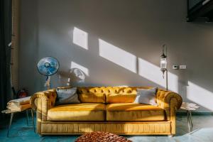 a brown couch in a living room with a wall at Loft apartmány FABRIKA in Vyhne