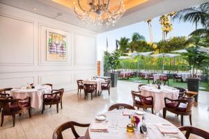 um restaurante com mesas e cadeiras e um lustre em Cameo Beverly Hills em Los Angeles