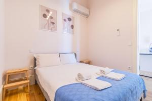 a bedroom with a bed with two towels on it at Duque Flat - AC & Balcony by LovelyStay in Porto