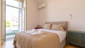 a bedroom with a bed with two towels on it at Duque Flat - AC & Balcony by LovelyStay in Porto