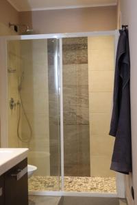 a shower with a glass door in a bathroom at Cà de sass 1891 in Vezzo