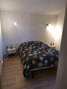 1 dormitorio con 1 cama con edredón negro y amarillo en Haut de villa rénovée en 2023, en Saint-Maime