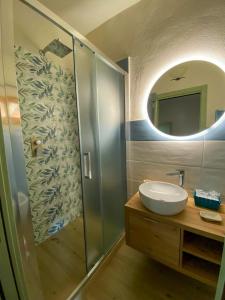 a bathroom with a sink and a shower with a mirror at I Due Cipressi in Torrenieri