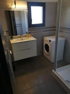 y baño con lavadora y lavamanos. en Haut de villa rénovée en 2023, en Saint-Maime