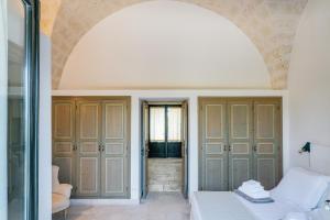 a bedroom with an archway and a bed in a room at Masseria Gorgognolo in Ostuni