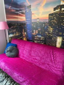 a hot pink couch in a room with a city at Komfort na Tamce,parter, niedaleko starówki, Powiśle in Warsaw