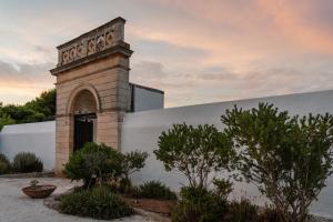 a building with a clock tower on the side of it at Masseria Gorgognolo in Ostuni