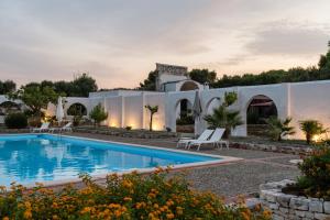 a villa with a swimming pool at dusk at Masseria Gorgognolo in Ostuni