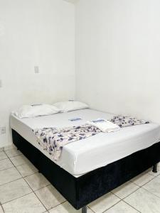 HOTEL AVENIDA في بيليم: سرير في غرفة بيضاء مع مرتبة