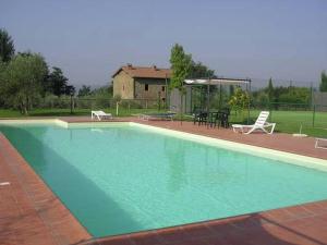 レッジェッロにあるPleasant holiday home in Reggello with poolの家屋を背景にした青い大型スイミングプール