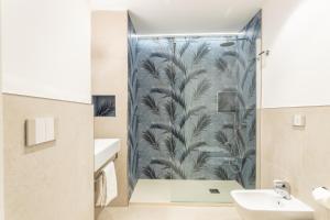 a bathroom with a shower with a blue wallpaper at Magnini Rooms in Cagliari