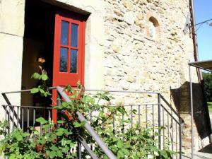 レッジェッロにあるPleasant holiday home in Reggello with poolの植物の石造りの建物の赤い扉