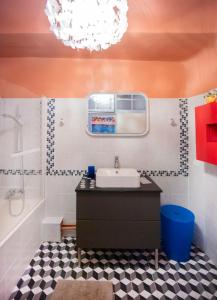 ein Badezimmer mit einem Waschbecken, einer Badewanne und einem Kronleuchter in der Unterkunft Très bel appartement avec une jolie vue dans le quartier prisé de Vauban in Marseille
