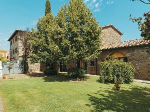 コルトーナにあるRustic Farmhouse in Cortona with Swimming Poolの庭に木のある古い石造りの家