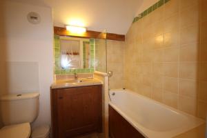 een badkamer met een wastafel, een bad en een toilet bij DATCHA Joséphine Immobilier in Serre Chevalier