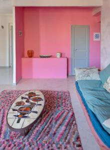 Zimmer mit einer rosa Wand und einem Surfbrett auf einem Teppich in der Unterkunft Très bel appartement avec une jolie vue dans le quartier prisé de Vauban in Marseille