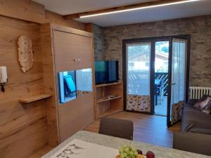 Bertuzzi Luxury Chalet في أبريكا: غرفة معيشة بها أريكة وتلفزيون